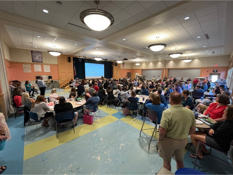 whole district kick off. Many teachers at tables.